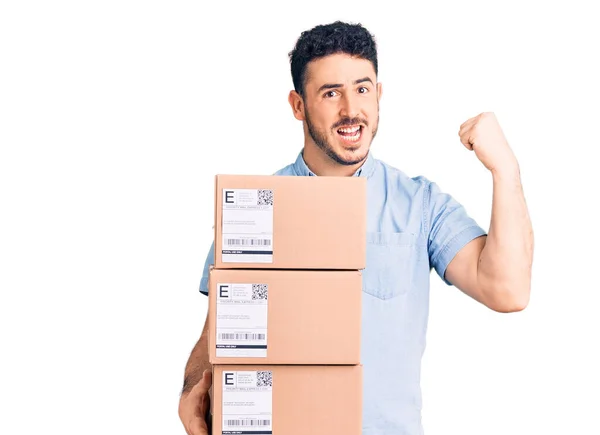 Young Hispanic Man Holding Delivery Package Screaming Proud Celebrating Victory — Stock Photo, Image