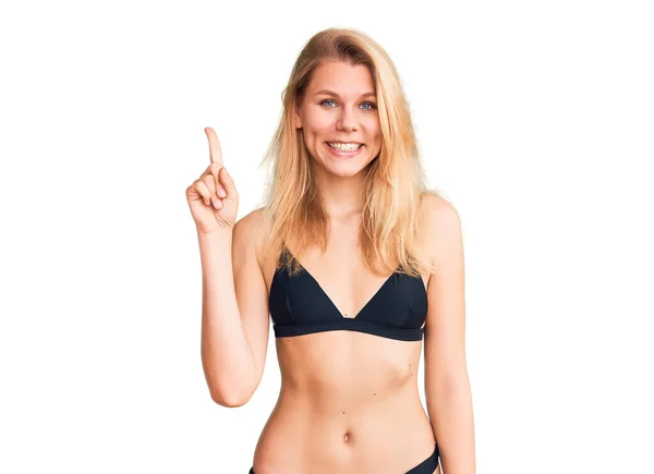 Genç Sarışın Bikini Giyen Güzel Bir Kadın Bir Numarayı Gösterip — Stok fotoğraf
