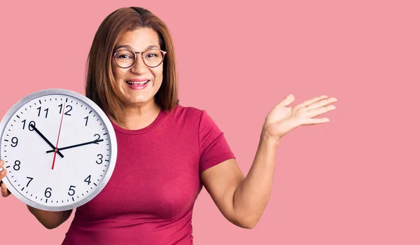 Mujer Latina Mediana Edad Sosteniendo Gran Reloj Celebrando Victoria Con —  Fotos de Stock