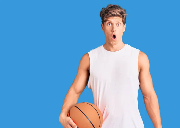 Joven Hombre Guapo Sosteniendo Pelota Baloncesto Asustado Sorprendido Con Boca — Foto de Stock