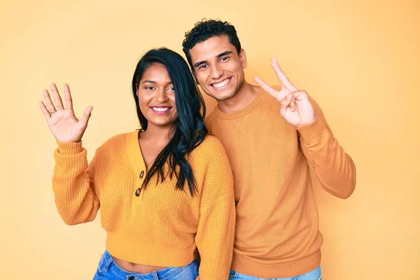 美しいラテン若いカップルを身に着けているカジュアル服一緒に表示し 指の番号8を指摘しながら 自信と幸せ笑みを浮かべて — ストック写真