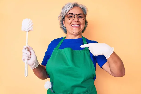 Senior Latinamerikansk Kvinna Bär Förkläde Hålla Borste Pekar Finger Till — Stockfoto