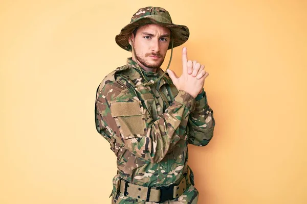 Ung Hvit Mann Med Kamuflasjeuniform Symbolsk Pistol Med Håndbevegelse Som – stockfoto