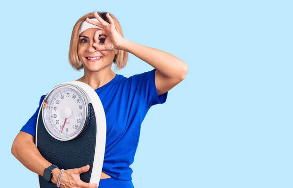 Young Blonde Woman Wearing Sportswear Holding Weighing Machine Smiling Happy — Stock Photo, Image