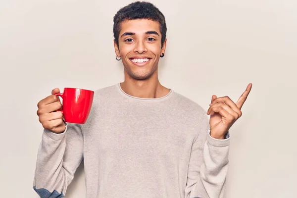 Jonge Afrikaans Amerikaanse Man Houdt Koffie Glimlachend Vrolijk Wijzend Met — Stockfoto