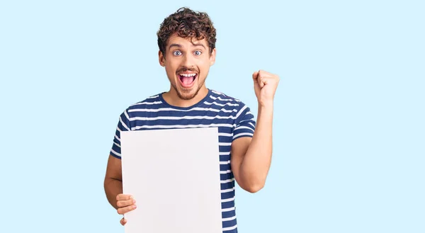 Jovem Homem Bonito Com Cabelo Encaracolado Segurando Banner Vazio Gritando — Fotografia de Stock