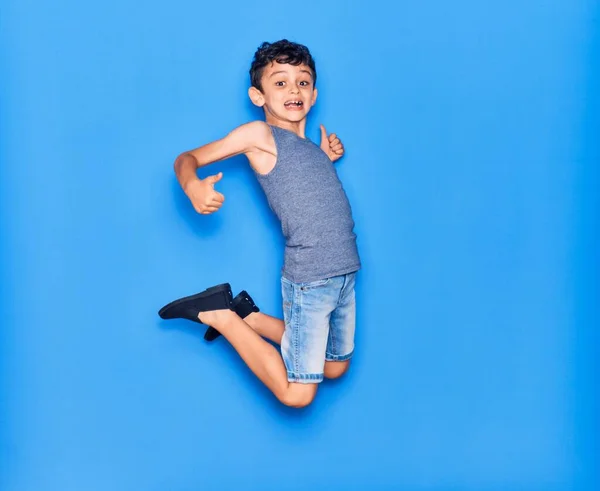 Adorable Niño Con Ropa Casual Saltando Sobre Fondo Azul Aislado — Foto de Stock