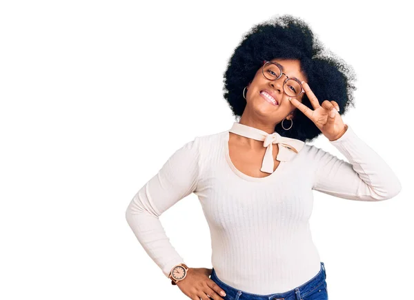 年轻的非洲裔美国女孩身穿休闲装 戴着眼镜 用手指捂住脸 愉快地微笑着 表示胜利 — 图库照片