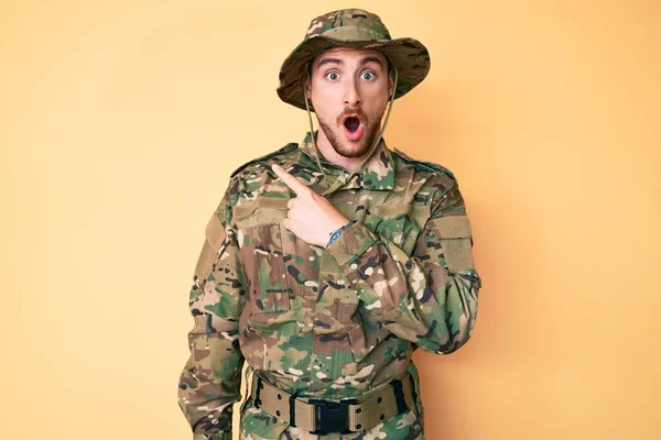 Young Caucasian Man Wearing Camouflage Army Uniform Surprised Pointing Finger — Stock Photo, Image