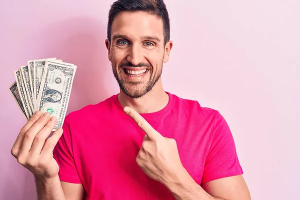 잘생긴 남자가 위에서 손가락으로 행복하게 가리키며 지폐를 — 스톡 사진