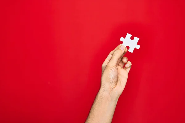 Schöne Hand Des Mannes Hält Puzzleteil Über Isoliertem Rotem Hintergrund — Stockfoto