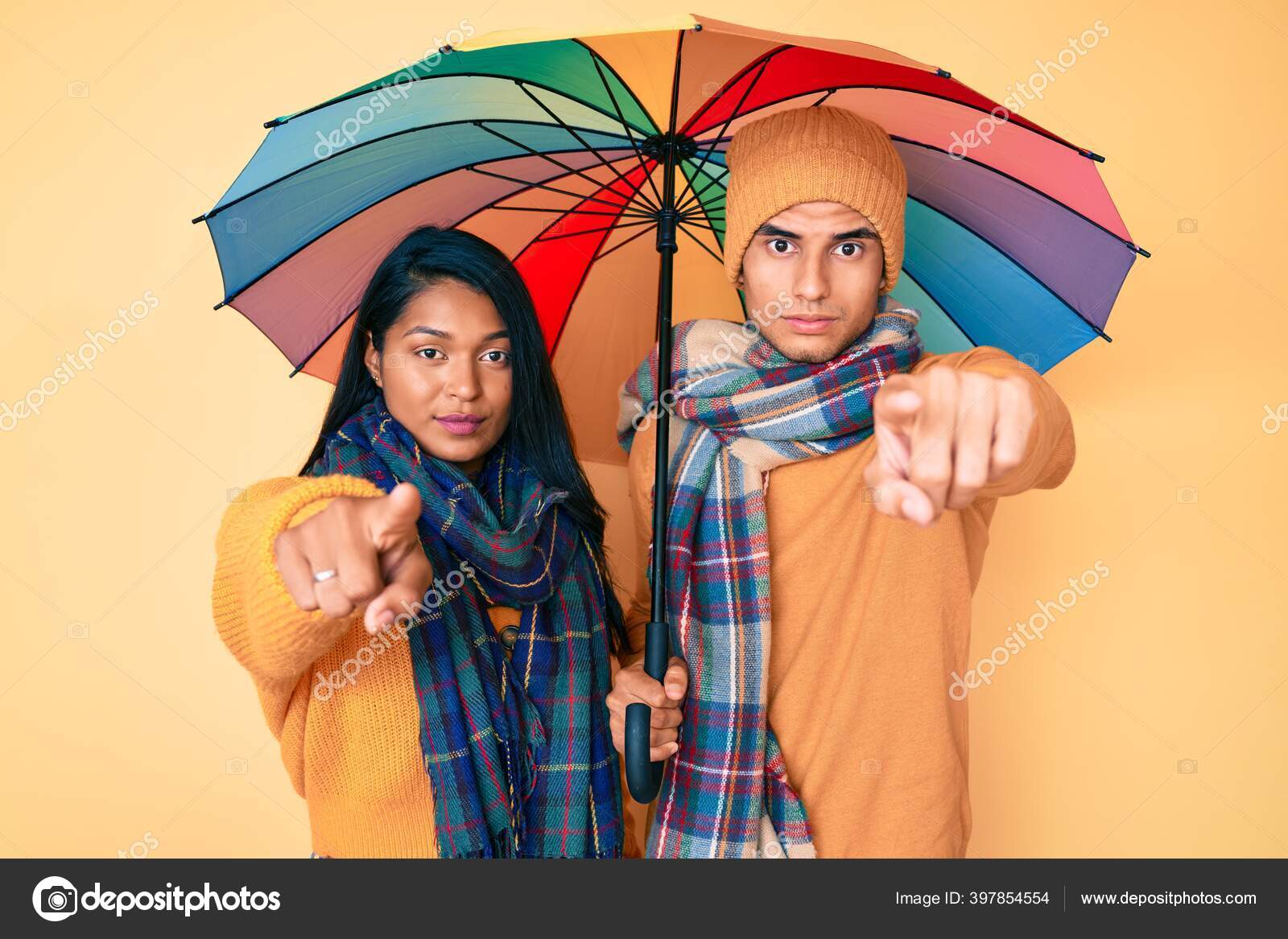 Hermosa Pareja Joven Latina Bajo Colorido Paraguas Apuntando Con Dedo: fotografía stock © Krakenimages.com #397854554 | Depositphotos