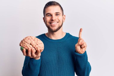 Bir fikir ve soruyla gülümseyen genç ve yakışıklı bir adam mutlu bir yüzle işaret ediyor, bir numara. 