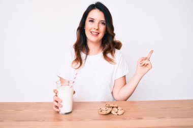 Genç, güzel esmer kadın, bir bardak taze süt ve kurabiyelerle gülümsüyor. 