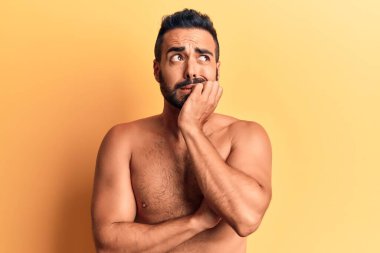 Genç İspanyol üstsüz, stresli ve gergin görünüyor. Ağzı tırnak ısıran elleri var. anksiyete. 