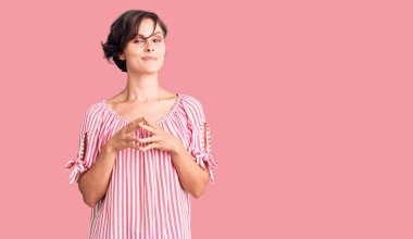 Kısa saçlı, yaz kıyafetleri giyen güzel genç bir kadın ellerini kavuşturup gülümseyerek gevşemiş ve neşeli olmasını diliyordu. Başarı ve iyimserlik 