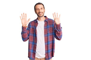 Gündelik kıyafetler giyen genç ve yakışıklı bir adam dokuz numarayı gösterip işaret ederken kendinden emin ve mutlu bir şekilde gülümsüyor.. 