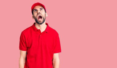 Sakallı, teslimat üniforması giyen sinirli ve öfkeli sinirli sinirli sinirli sinirli sinirli sinirli bağıran genç bir adam. öfke ve agresif konsept. 