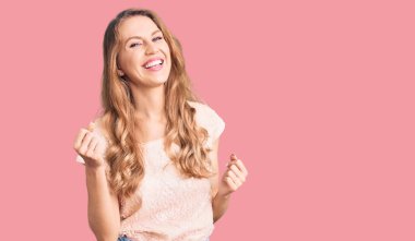 Sarışın, güzel, beyaz bir kadın kolları havada ve gözleri kapalı bir şekilde başarısını kutluyor. Kazanan konsept. 