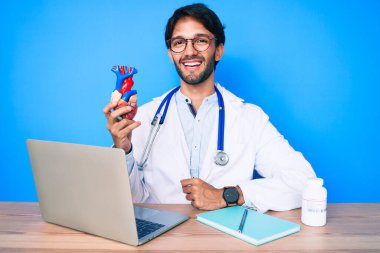 Yakışıklı, doktor üniforması giyen, kalbi olan, mutlu ve pozitif görünen, kendine güvenen, gülümseyen, dişlerini gösteren yakışıklı bir adam. 