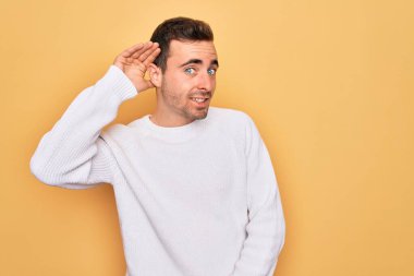 Mavi gözlü, sıradan bir süveter giyen, sarı arka planda dikilen, kulağına fısıldayan, dedikodu ve dedikoduları dinleyen genç yakışıklı bir adam. Sağırlık kavramı.