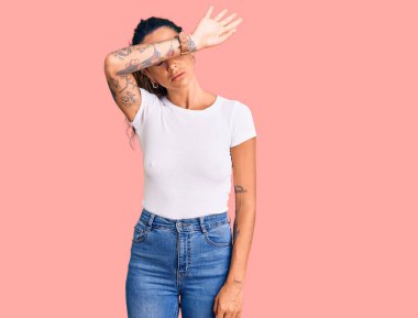 Gündelik beyaz tişört giyen, kollarını kollarıyla kapatan, ciddi ve üzgün görünen İspanyol bir kadın. Görme, saklama ve reddetme konsepti 