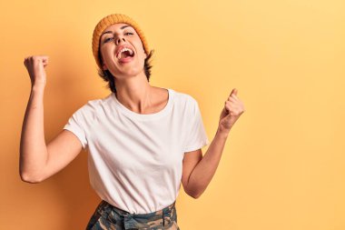 Yün şapkalı genç bir kadın gururla bağırıyor zaferi ve başarıyı kutluyor. Kollarını kaldırarak heyecanlanıyor. 