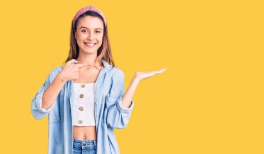 Gündelik tişört giyen genç ve güzel bir kız kameraya hayret ediyor ve gülümsüyor.. 