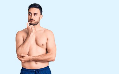 Mayo giyen genç yakışıklı adam ciddi bir yüz ifadesi takınıp eli çenesinde soru sormayı düşünüyor. Kafa karıştırıcı bir fikir. 