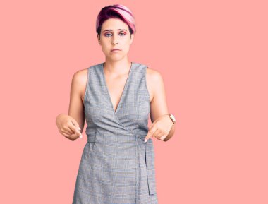 Pembe elbiseli genç bir kadın üzgün ve üzgün görünüyor. Mutsuz ve depresif.. 
