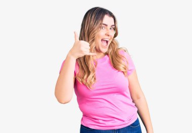 Beyaz kadın spor kıyafetleri giyiyor, gülümsüyor telefonla el ve parmaklarıyla jest yapıyor, telefonda konuşuyor gibi. iletişim kavramları. 