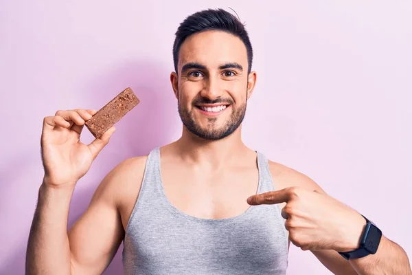 Young Handsome Man Beard Eating Energy Protein Bar Isolated Pink — Stock Photo, Image