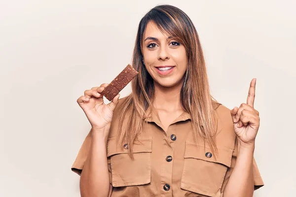 Jovem Mulher Bonita Comendo Barra Proteína Energia Sorrindo Feliz Apontando — Fotografia de Stock