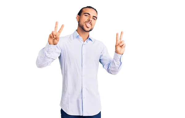 Mladý Pohledný Muž Pracovních Šatech Usmívající Vystrčeným Jazykem Ukazující Prsty — Stock fotografie