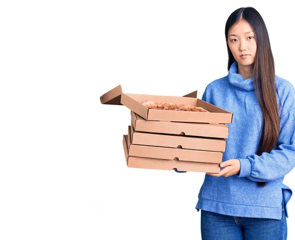 若い美しい中国の女性は イタリアのピザの思考態度と落ち着いた表情の段ボール箱を保持自信を持って見える — ストック写真