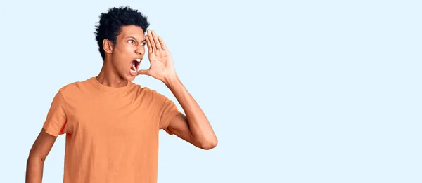若いアフリカ系アメリカ人の男性は カジュアルな服を着て大声で叫び 口の上に手で大声で叫ぶ コミュニケーションの概念 — ストック写真