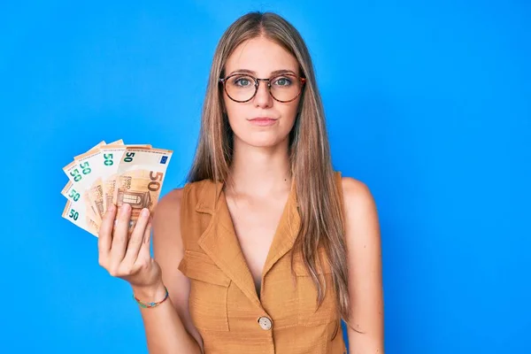 Menina Loira Jovem Segurando Notas Euro Relaxado Com Expressão Séria — Fotografia de Stock