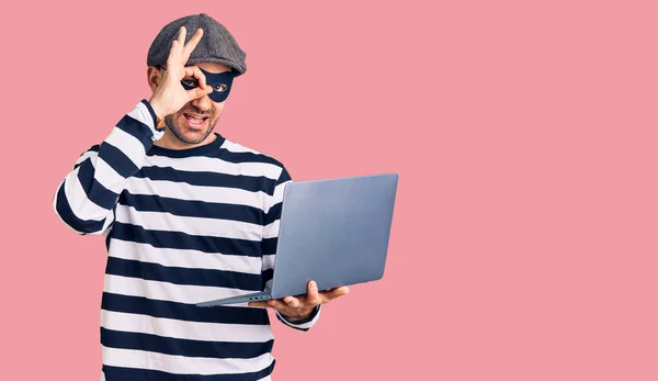 Jonge Knappe Man Draagt Inbraak Masker Met Behulp Van Laptop — Stockfoto