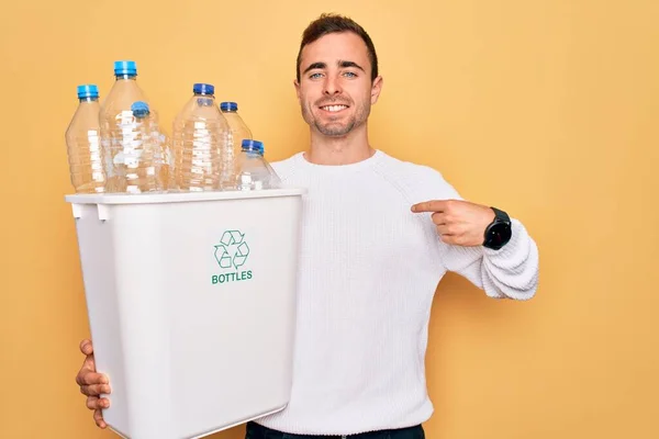 若いですハンサムな男とともに青い目リサイクル保持Wastebasketとともにプラスチックボトル指差し指に1つの自己笑顔幸せと誇り — ストック写真