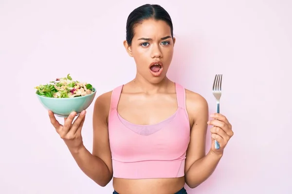 Young Beautiful Latin Girl Wearing Sportswear Holding Salad Shock Face — Stock Photo, Image