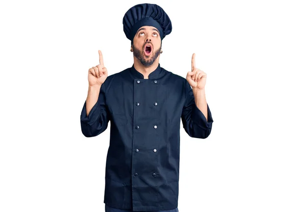 若いですヒスパニック男身に着けている炊飯器の制服驚きと驚きを見上げと指差すと指と上げ腕 — ストック写真