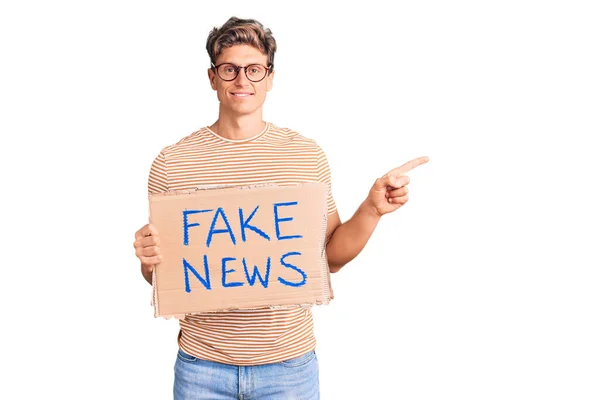 Young Handsome Man Holding Fake News Banner Smiling Happy Pointing — ストック写真