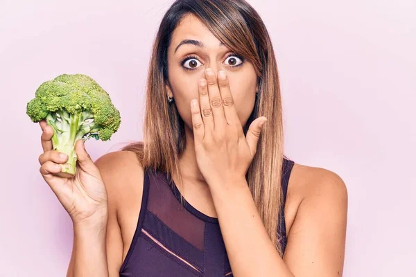 Ung Vacker Kvinna Håller Broccoli Täcker Munnen Med Handen Chockad — Stockfoto