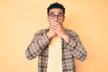 Sıradan kıyafetler ve gözlük takan genç, yakışıklı İspanyol adam yanlışlıkla ağızlarını kapatarak şok etti. gizli kavram. 