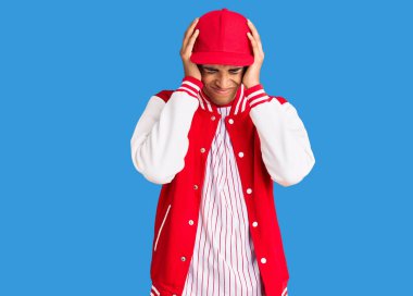 Beyzbol üniforması giyen genç Afro-Amerikalı adam acı ve migren yüzünden çaresiz ve stresli. Eller başının üstünde.. 