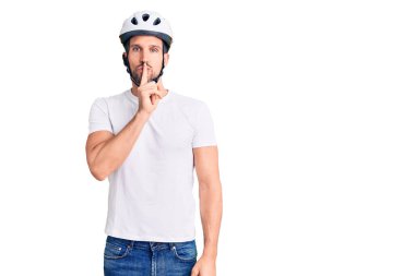 Bisiklet kaskı takan genç yakışıklı adam sessiz olup dudaklarını öpmek istiyor. sessizlik ve gizli konsept. 