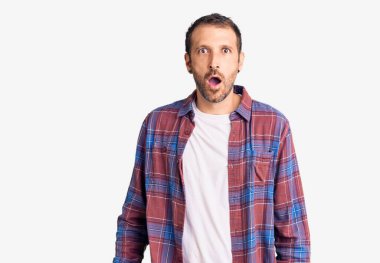 Gündelik kıyafetler giyen genç yakışıklı adam şaşkınlık ve şaşkınlık dolu bir ifade, korku ve heyecan dolu bir yüz ile şoka uğradı.. 