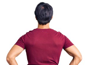 Yakışıklı İspanyol bir adam, sıradan kıyafetler giyiyor. Arkaya bakıyor ve kollarını vücuduna dikiyor. 