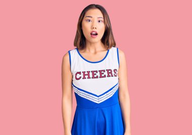 Genç, güzel Çinli kız amigo üniforması giyiyor. Şaşırmış ve şaşırmış bir ifade, korku ve heyecanlı bir yüz.. 