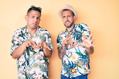 Yaz şapkası ve Hawaii gömleği giyen iki genç gay, tiksindirici ve tiksindirici bir yüz ifadesi takınıyorlar.. 